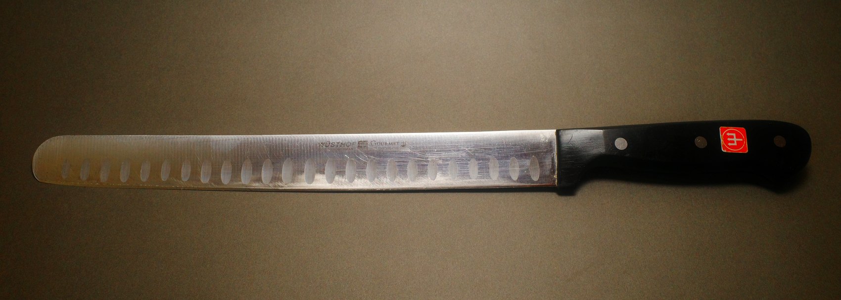 Hollow-edge carving slicer before sharpening, blade marked and dull