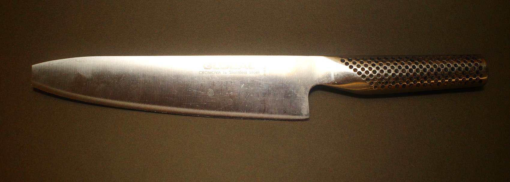 Global chef knife before sharpening, blade marked and scratched from years of use