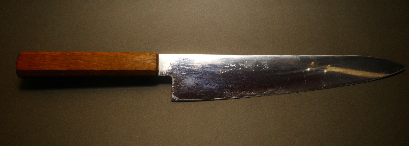 Japanese gyuto with a wooden handle before sharpening, blade scratched and dull